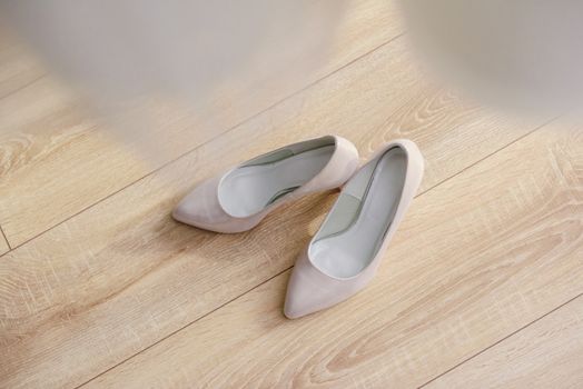 The bride shows white wedding shoes. Wedding detail. Close up