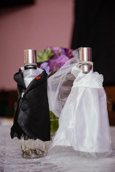 Bottle of cold vodka and wine bottle in bucket with ice and orange juice in jug on table, copy space. Alcohol bottles in ice bucket in restaurant. Wedding party