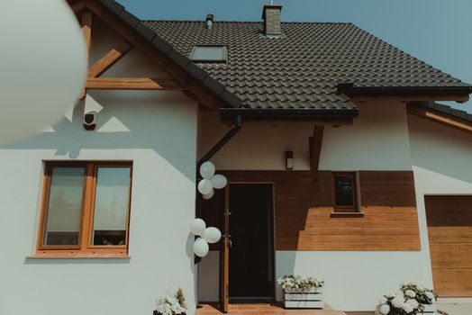 modern house exterior. decorated with white balloons.