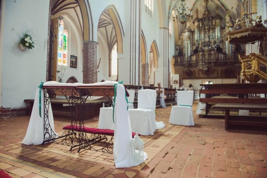 Church sanctuary before a wedding ceremony. Empty chairs for bride and groom