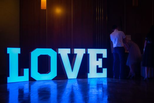 Illuminated Love sign in large letters at a wedding reception.