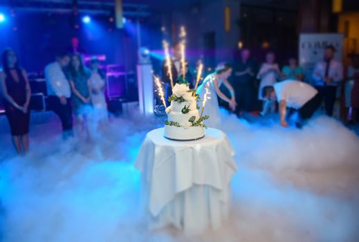 Delicious Wedding Cake at the party. Smoke and fire effects