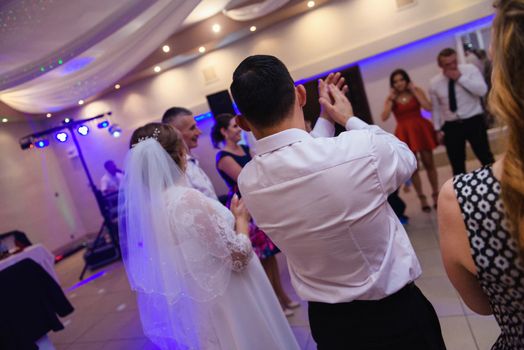Bride and groom dancing the first dance at their wedding day. Guest on the dancefloor
