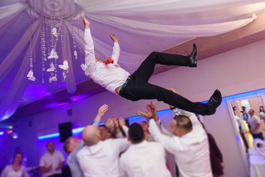 Bride and groom dancing the first dance at their wedding day. Guest on the dancefloor