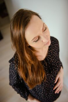 A photograph of pregnant woman relaxing on chair at desk in room.