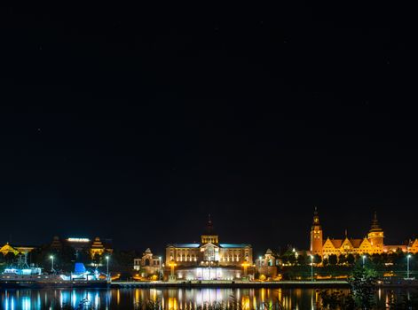 Szczecin. Night view from across the river to the illuminated historic center. Odra river. Chrobry embankments in Szczecin