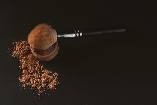 close up of a make up powder and a brush. makeup brush with powder foundation