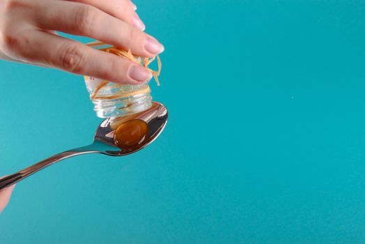 close up of honey jar on blue background
