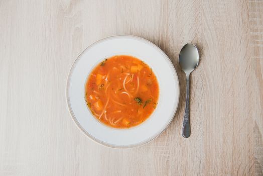 Bowl of tomato soup isolated on a white background.