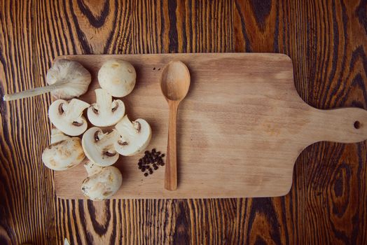 composition poured olive oil, mushrooms, garlic on wooden background. healthy food
