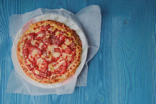 Homemade pepperoni pizza on the table. Tomato, cheese and ham main ingredients.