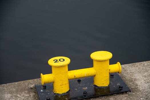 Two yellow mooring post at the harbor or marina port.