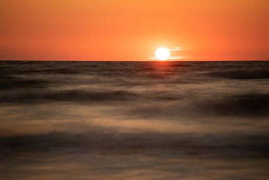 A photograph of wooden breakwater and seagulls at sunset on the Baltic Sea