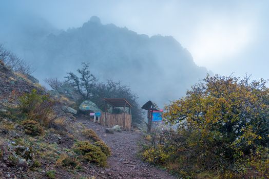 Hiking trail in the mountains, autumn landscape in the fog