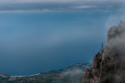 View of the mountains, coast and sea through the clouds from a height