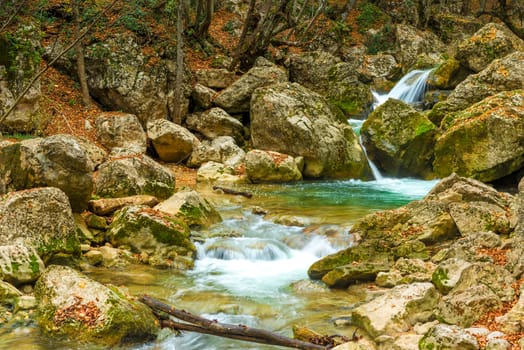 Large boulders in the gorge of the mountains, where the fast cold river flows, autumn landscape