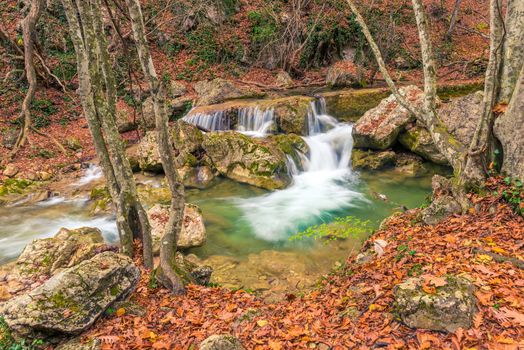 in a beautiful natural location in the autumn mountain forest small waterfalls and a river