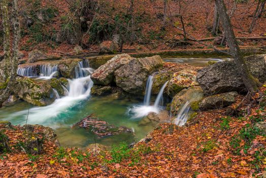 small waterfalls and a river postcard view in a beautiful natural location in the autumn mountain forest