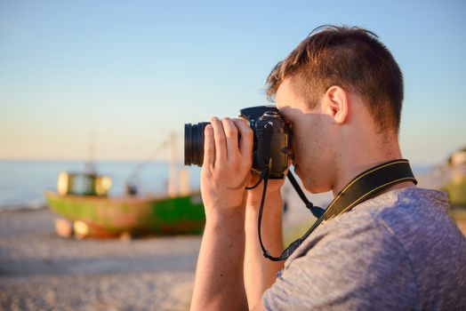 Silhouette of young photographer on the beach. Summer time