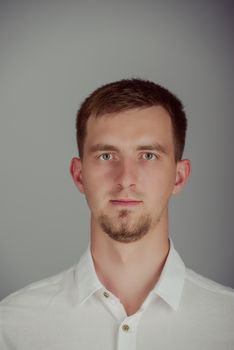 Portrait of a smiling young brunette man in studio