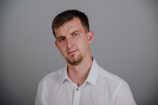 Portrait of a smiling young brunette man in studio
