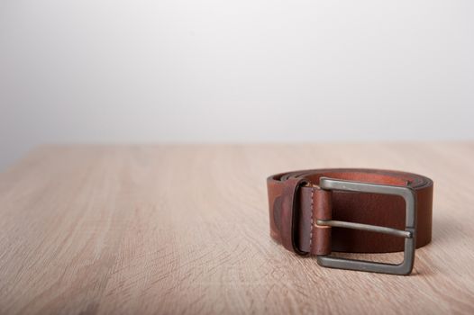Leather belt on the wooden desk table