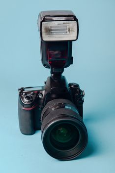Professional modern DSLR camera against blue background