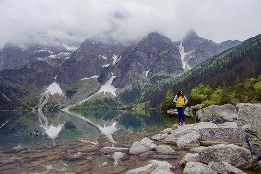 woman relaxing on the lake and mountains sunny landscape.