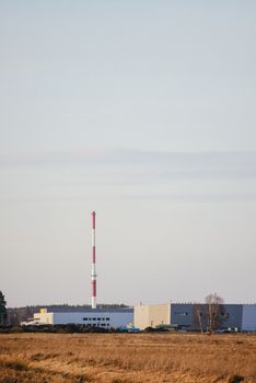 modern exterior of an industrial building, surrounded by a fence with iron gate