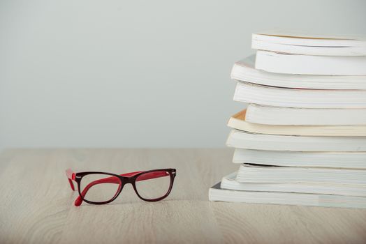 book and eyeglasses on wood background desk
