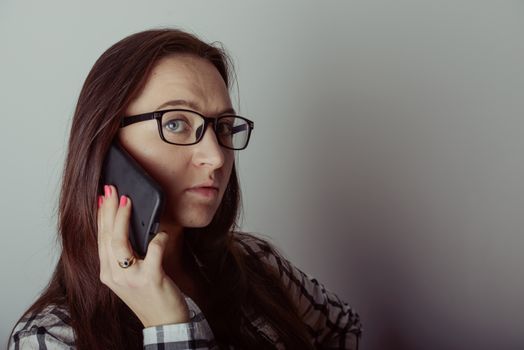 Happy brunette girl talking via smartphone at home