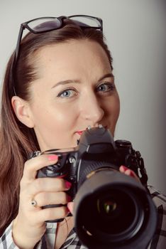 Woman-photographer takes images, isolated on gray background