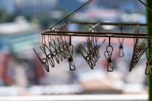 The metal clothespins hanging with wire on blur background.