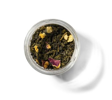 Green tea with aromatic additives. Top view on white background.