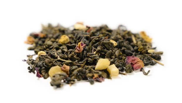 Green tea with aromatic additives. Top view on white background.