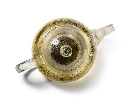 Hot green tea in glass teapot on white background.