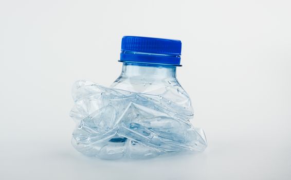 Closeup on empty trash crushed bottle of spring water isolated on white