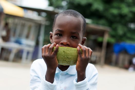 child eats a watermelon with love in the street.