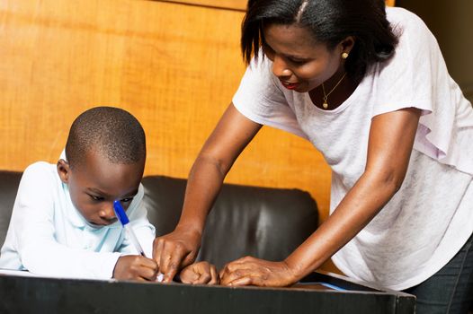 Mom shows her child where he has to write in his notebook.