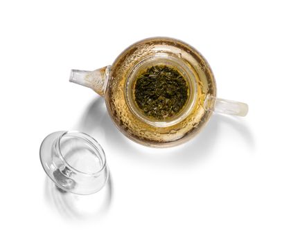 Hot green tea in glass teapot on white background.