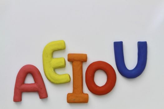 colored vowels in clay with white background