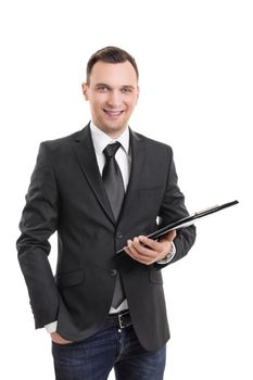 Handsome confident smiling businessman in a suit standing and holding a clipboard, isolated on white background. Young attractive businessman wearing a suit and tie, holding a notepad.