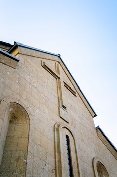 modern christian church with a cross on the wall against the blue sky in Georgia