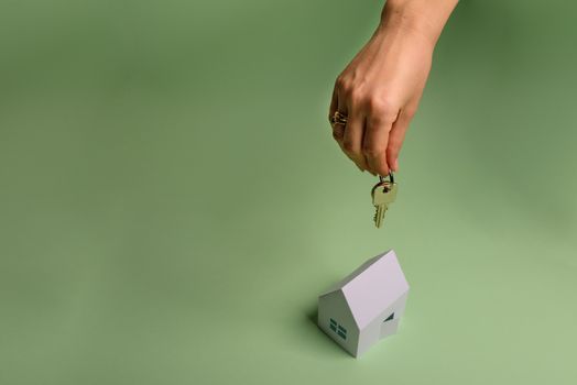 White family paper house , stack of money coins, house projects plan and blueprints on mint background paper. Minimalistic and simple concept, style. Vertical orientation