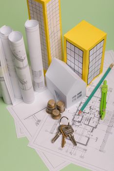 Paper skyscrapers , euro money, house projects plan and blueprints on blue background paper. Minimalistic and simple concept, style. Vertical orientation. View from above.