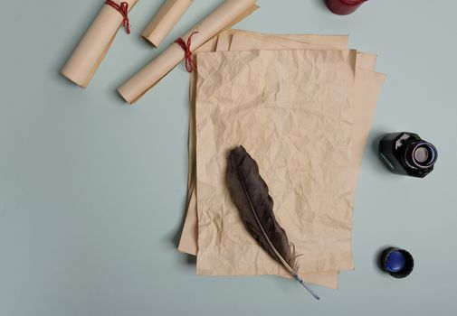 Raven feather, inkwell and old yellowed paper on red background. Copy space. Old letter.