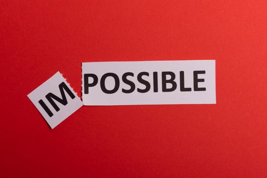 Impossible text cut out. Possible concept. Success. Pink background. Copy space. Vertical orientation. View from above. Minimal simple style