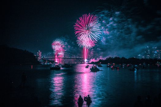 In images Beautiful colorful holiday fireworks in the evening sky with majestic clouds, long exposure