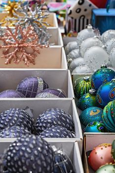 Christmas decoration. Red, yellow, blue and pink glass balls are in boxes in the store.