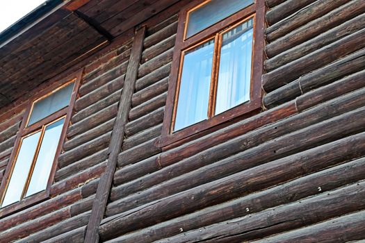 An element of the architecture of an old wooden house made of logs. Vintage style, eco-friendly residential building.